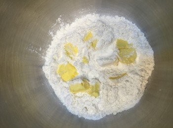 step1: 将中筋麵粉＋砂糖＋鹽＋泡打粉混合過篩，加入切小粒的牛油一起搓成粉粒。
