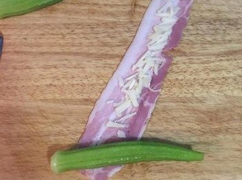 step4: 取一條培根，鋪上適量起司條，斜放上冰鎮後瀝乾的秋葵一條。