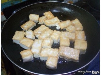 step3: 先將平底鍋燒熱之後，倒入適量的沙拉油，再灑入少許的鹽巴 將豆腐煎至兩面微焦後起鍋備用