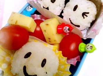 step3: 用打孔笑臉將紙菜打出眼及咀黏上飯團上完成，最後用食物膠籤拮車厘茄及芝士放入食物盒內