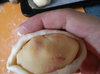 step18: 將1份麵糰按扁,搓成長兜形,包入餡料埋口,埋口方向向底,放入已加牛油紙的焗盤上.(如皮難搓,可用一張保鮮紙,底面包起麵糰就會易搓)