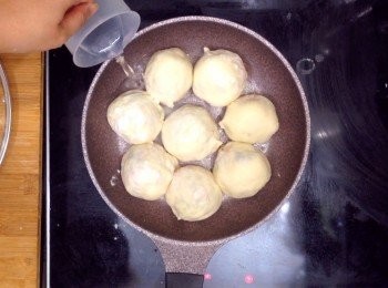 step12: 包子都包好後，煎鍋先下點油，開火，冷鍋把包子放上鍋，先煎至底部有一點點金黃，之後下水，水量至四分一或五分一的高度即可（因<span class="group_3">內餡</span>已熟，只是煎熟包皮），之後中小火煎至水乾得差不多，