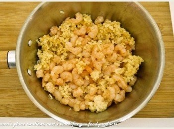 step4: 將白飯炒熱後，加入蝦仁炒煮至熟，並添加些許醬油來增色。