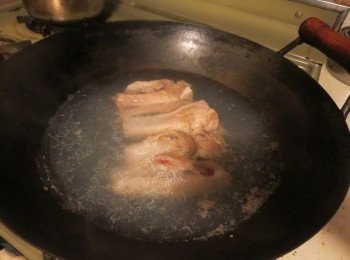 step2: 锅里放入适量的水，加入少許料酒，放入排骨不盖盖煮3-5分钟，中途需翻动。这时可以看到排骨的表面和骨头里有浮沫溢出，这些浮沫也是腥源：焯过水的排骨用清水冲干净表面的浮沫。
