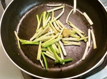 step2: 熱油鍋後，放入薑片與青蔥的前半段來爆炒片刻。