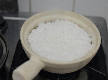 step2: 瓦煲內塗一層食用油，倒入已泡浸的米及水，蓋上蓋，用中大火煮約10- 12分鐘，至水收乾