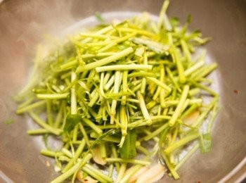 step3: 利用同一個鍋子，將蒜頭下鍋爆香後，加入空心菜梗約略拌炒。