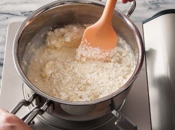 step4: 關火，用耐熱刮刀攪拌麵糊至全部和成一團為止。再次開火，一邊加熱一邊攪拌麵糊，煮到鍋底出現薄薄一層白色的薄膜就關火。