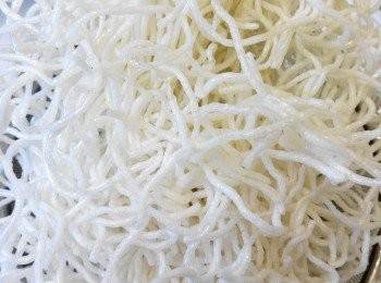 step4: 米粉用沸油炸香；这个炸制过程建议将适量米粉放入一个笊篱内，然后连同笊篱一起下油锅，米粉接触沸油的瞬间就会膨松，像爆米花的状态。此时要立即将笊篱拿离油锅。
瀝乾油分準用。