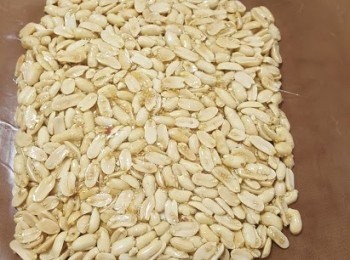 step3: 當糖漿轉為金黃色，糖漿的泡沫越來越細，溫度達160度，把溫熱的花生及白芝麻倒入鍋中，快手拌勻，倒在耐高溫的不沾布上(小心糖果很熱，不要直接觸摸)再蓋上另一塊不沾布，用麵棍推壓，將花生糖壓平