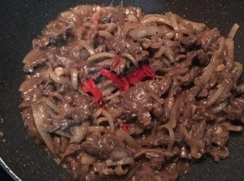 step7: 牛肉炒半熟後，放入<span class="group_3">調味料</span>（沙茶醬最後放）和少許的水，大火快炒到牛肉都熟了，再放入辣椒拌炒。