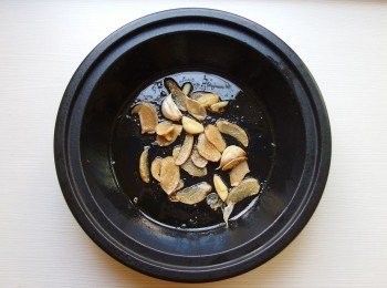 step2: 將麻油及蒜頭薑片一起下鍋(喜歡辣一點的,辣椒可下鍋),用小火慢慢煸香,煸至薑片捲起狀。
