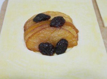 step6: 接著把有洞的派片黏在塗上蛋液的派皮上!!中間凹處則鋪上焦糖蘋果和葡萄乾~~派皮周圍也塗上蛋液!!放進預熱190度烤箱烤約8-10分鐘即完成嚕:)