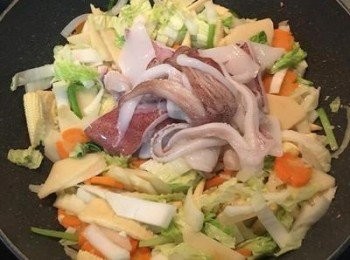 step7: 接著放入白菜或高麗菜加一匙鹽ㄧ起炒軟，接著在鍋中間撥出ㄧ個位置，放入切好的花枝或透抽炒半熟。