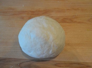 step10: 將麵團放在桌上，然後再用手掌根部反覆用力地搓揉成一個光滑不黏手的麵團。