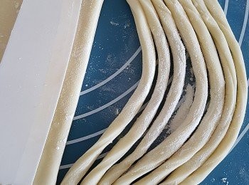 step3: 切麵糰之技巧，切勿將頭尾切斷、6-7條為一組切斷之後，用手撥向右方繼而成為扭繩狀