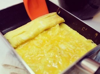 step2: 先燒熱煎鍋，蛋漿液分三次，下蛋後，用手拿起煎鍋，令蛋液均勻於鍋面。用小鑊鏟輕輕捲起，再下蛋液，重覆動作兩次。