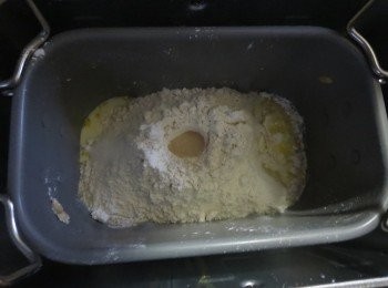 step1: 依材料表由上而下的順序放入麵包容器。液体(牛奶，蛋，牛油)先投入面包桶 盐和糖分别放在不同角落 ，然后加入面粉 ，在面粉上戳一个小洞放酵母。