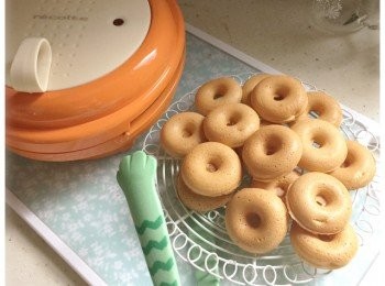 step3: 將微笑機預熱。粉漿入唧袋，微笑機燈號熄滅後，將粉裝倒進模內，焗三分鐘便可。取出甜甜圈，放涼。