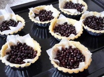 step4: 在撻上鋪上烘焙紙，再放上米或豆（這可防止塔皮上升）放入焗爐180度焗15至20分鐘至表面乾