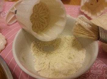 step13: 將月餅模及每個月餅都要掃上底筋粉,再澄出多餘粉,否則太多粉會影響花突出效果(每做一個月餅都要掃1次粉)