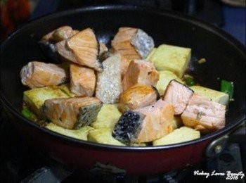 step5: 使用原鍋，放入蔥末段，蒜末及薑末爆香後，再倒入醬油，米酒後 放入先前煎好的雞蛋豆腐及鮭魚塊