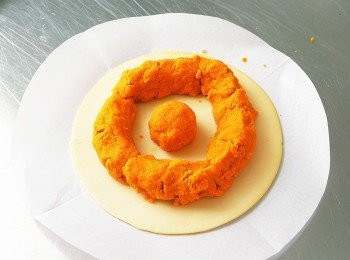 step4: 將1張派皮放在烘焙紙上，再將直徑4㎝左右揉成圓球狀的<span class="group_2">南瓜醬</span>放在派皮的中心位置。在距離中心的<span class="group_2">南瓜醬</span>約1.5㎝左右的位置，像畫圓一樣放上剩餘的<span class="group_2">南瓜醬</span> 。