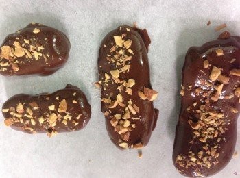 step3: 將大蕉乾片放入已推滑的朱古力漿內沾染至整塊都完全被朱古力包裹著便可取起小心放在牛油紙上並灑上杏仁碎粒