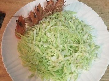 step6: 冰鎮後的高麗菜絲先瀝乾水份，鋪擺在盤子上，前面可用剝下來的蝦頭做裝飾。