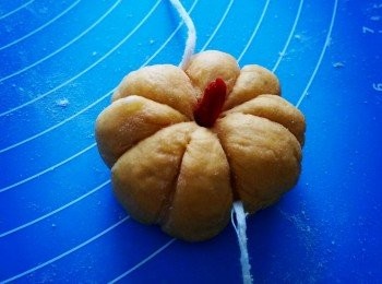 step6: 將小糰子分別揉成饅頭狀，取壹根幹凈的細線，稍微用力在南瓜包上壓出痕跡，切記要深壹點為好，否則在蒸鍋蒸熟後會變得不清晰。