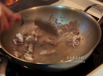 step5: 把1湯匙油放鑊中燒熱，下餘下的蒜茸、紅椒絲和<span class="group_2">調味汁</span>爆香，再下鮮魷以大火炒勻。
