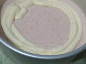 step6: 先把一半份量的草莓芝士糊倒入蛋糕模內然後舀入檸檬芝士糊，再倒入餘下的草莓芝士糊後用筷子插入以S字形畫紋，再倒入最後的檸檬芝士糊抹平。