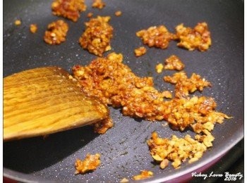 step5: 電鍋在蒸魚的同時，來準備調味醬： 熱鍋之後，倒入少量的油，再倒入蒜酥，仔細的拌熱後放入辣豆瓣醬炒開 之後再倒入剛才蒸魚後盛起來的湯汁，將豆瓣醬稀釋拌熱，起鍋之前再灑入蔥末即可