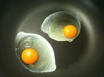 step3: 取出平底鍋，用餐巾紙沾取少許苦茶油（或其他耐高溫的油品也可以）抹在鍋底，開中火，將步驟2的蛋輕輕倒入，蓋上鍋蓋。大約5秒後，拿起步驟2裝水的碗，打開鍋蓋，對著蛋噴水（不可以用倒的，要用噴的哦。噴個二、三下就可以了），再將鍋蓋蓋上，待蛋白凝固時，太陽蛋就完成囉。