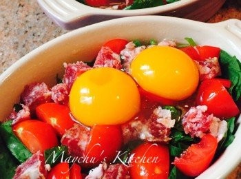 step2: 小焗盤內先抹油，然後放入菠菜苗、車厘茄及辣肉腸。雞蛋先打進碗中檢查確保沒有蛋殼或雜質再倒在配菜上，加鹽和黑椒調味。放入焗爐180度焗約8分鐘至蛋白開始變白凝固。