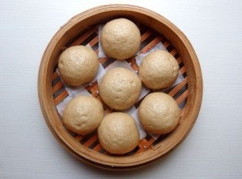 step6: 將麵糰擀成圓形,包入豆沙內餡。將包好的黑糖豆沙包放在烘焙紙上,整齊排放在蒸籠上做最後發酵(時間約15-25分鐘不等,發酵時間需依照氣候溫度而定)。