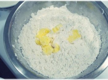 step2: 在碗中將麵粉過篩..加入泡打粉,鹽,糖..攪拌均勻後~~ 在把奶油放進去~~並用手指將奶油搓捏搓捏!!