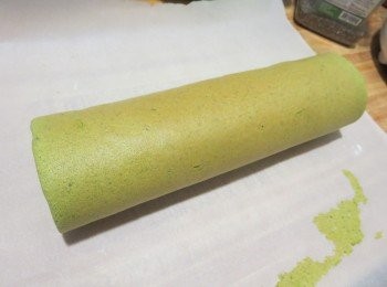 step8: 将卷棒置于烘焙纸下，将烘焙纸从一边轻轻卷起。完全卷好用力压紧卷口处定型。再包一层烘焙纸固定形状，然后放入冰箱冷藏1小时切件。