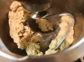 step2: 將已過篩的麵粉、鹽、糖和乾酵母放入攪拌盤中混合均勻，然後倒入已溶化的牛油、牛奶和蛋黃用攪拌機打發成麵糰。