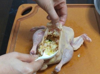 step4: 用匙羹將炒飯釀入雞腔內， 期間用匙羹按壓， 務求將炒飯釀得結實點， 雞要釀得飽滿才好 -------   釀飯示範 youtube video:  https://www.youtube.com/watch?v=ou3ol80pLJw