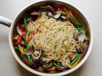 step7: 約一分鐘後蛤蜊開口後,放入義大利麵和彩色甜椒及甜碗豆拌炒,加入一些煮麵水讓麵條都巴住醬汁(可稍微搖鍋或甩鍋一下,讓醬汁均勻巴住麵條),起鍋前加入香草(巴西里及羅勒)拌炒一下