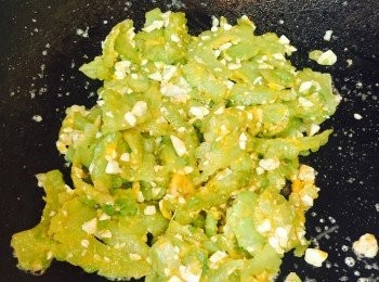 step5: 然後放苦瓜和咸蛋黃，快炒至蛋黃溶化並沾在苦瓜上，加糖、蒜蓉和葱花兜匀即成。
