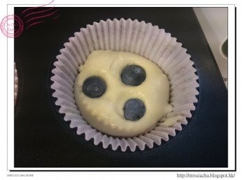 step7: 把鬆餅紙杯放入模具內, 倒入少許蛋糕液, 加入數粒藍莓及忌廉芝士塊。