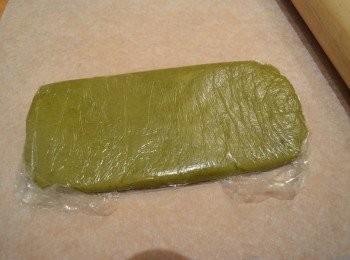 step10: 冷藏鬆弛半小時後，先取出綠色麵糰，在麵糰上鋪上保鮮膜，下面也可放上烘焙紙或保鮮膜，這樣可較易桿麵糰。綠色麵糰隔著保鮮膜用桿麵棍桿成一個約25cm x 8cm 左右的長方形，厚度大約2cm。