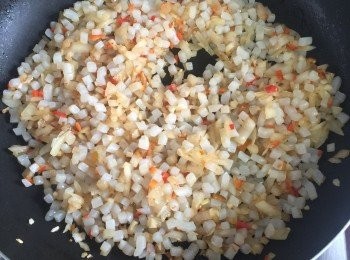 step5: 原鍋下一大匙蔬菜油，中小火炒洋蔥碎、蒜末，洋蔥末炒至透明後加入蒟蒻丁丁拌炒均勻，加入小蕃茄和辣椒末拌炒。