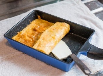 step6: 打開蓋子，把鍋子放在濕布上，以小鍋鏟把蛋卷由底向上捲上。