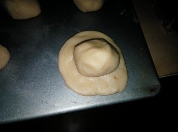 step5: 把水皮面剂子稍微压扁，用水皮来包入油皮面剂子，滚圆，把封口朝下，放置松弛一会。