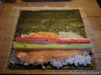 step2: 捲簾→海苔→壽司米→鮭魚(火腿片亦可)→蟹肉條→小黃瓜→白芝麻(依個人喜好添加)。
