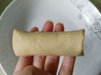 step6: 向前卷起來，卷緊成筒狀；多余的壹角塞進筒中包住肉餡，壹個百葉包做好。