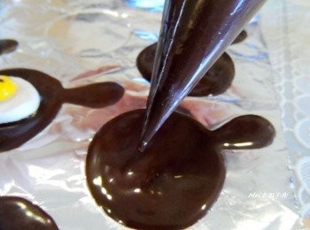 step4: 將隔水加熱融化的黑巧克力擠在平底鍋形狀凹槽的錫箔紙上